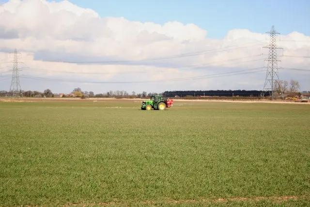 Un trattore sparge concime su un campo